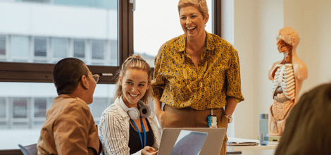 student doctors smiling and working on laptop